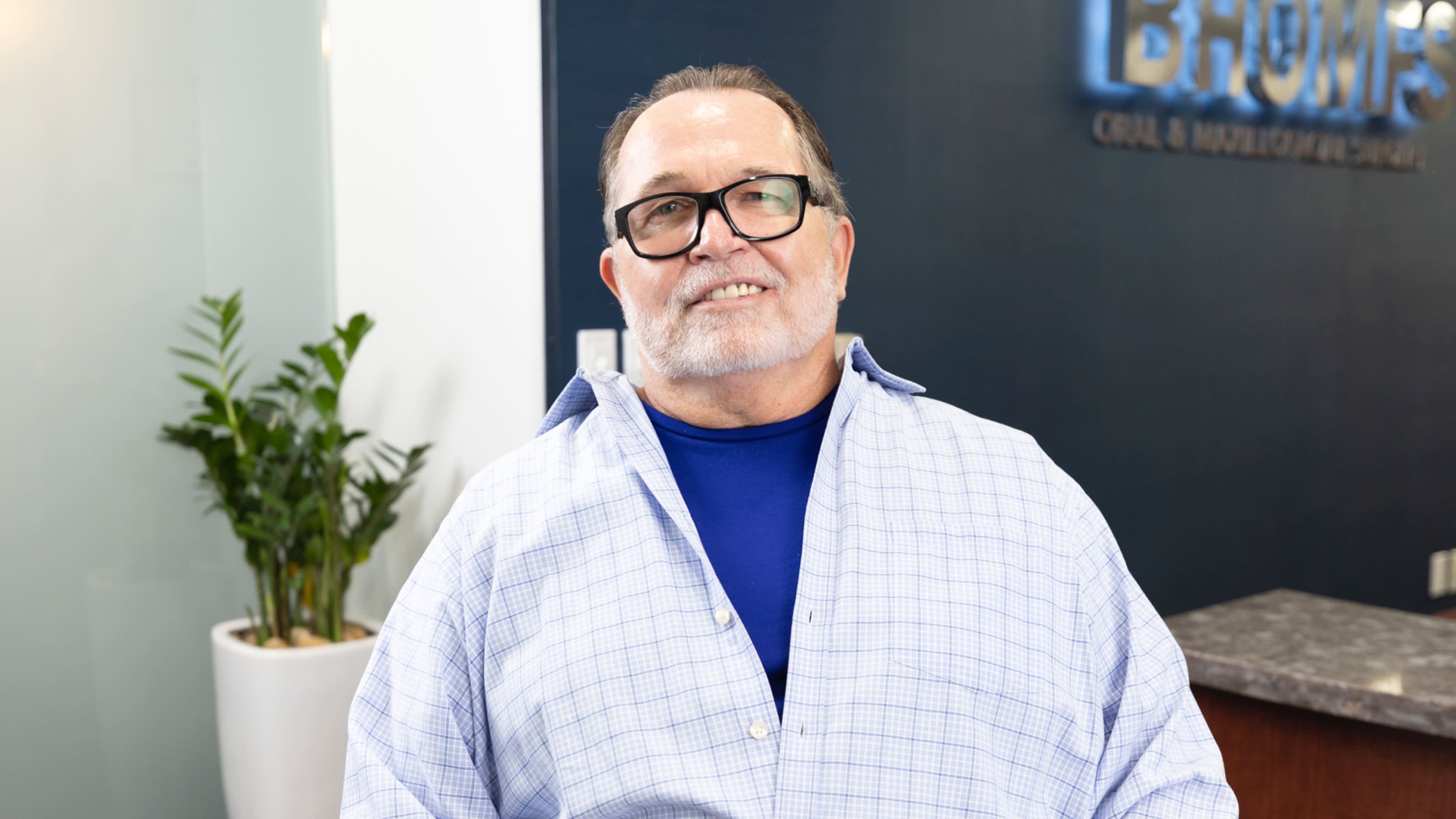 Smiling man in a checkered shirt.